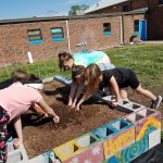 Children with hands in the garden soil
