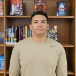 Alex Pulley standing in front of book shelving